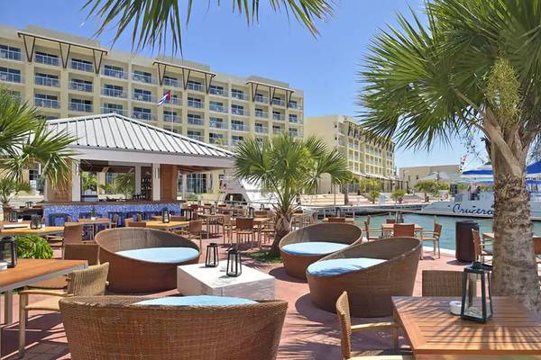 Außenbereich des Melia Marina Varadero Hotels mit Tischen, Stühlen und Palmen.
