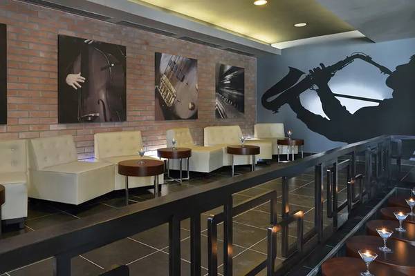 Innenbereich des Melia Marina Varadero Hotels mit weißen Sofas, runden Tischen und Kunstwerken an der Wand.