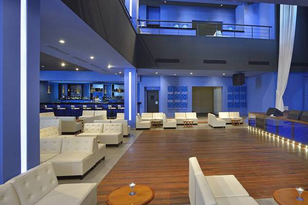 Lobby des Melia Marina Varadero Hotels mit weißen Sofas, blauen Wänden und einer Bar.