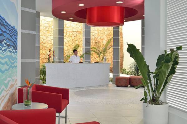 Empfangsbereich des Melia Marina Varadero Hotels mit roter Decke und Rezeptionstisch.