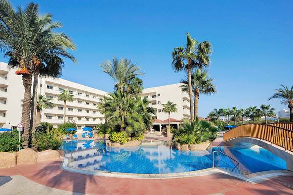 Außenbereich des Nissiana Hotels mit Swimmingpool und weißen Gebäuden