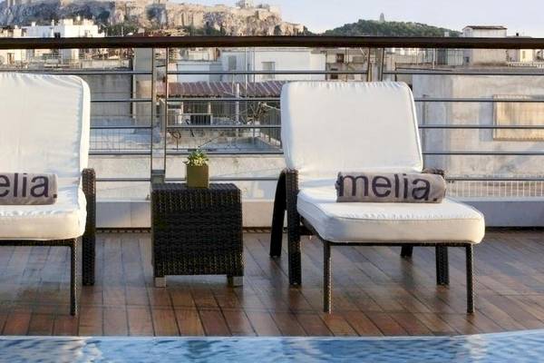Dachterrasse des Melia Athens Hotels mit zwei weißen Sesseln und einem Pool