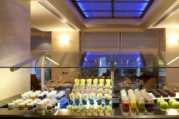 Buffet-Tisch im Melia Athens Hotel mit verschiedenen Desserts und Getränken.