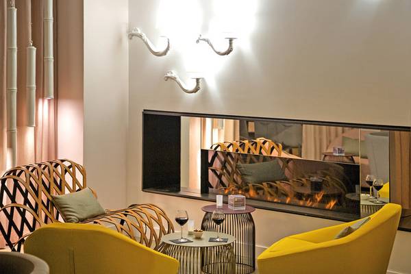 Hotellounge im Mercure Paris Montmartre Sacré-Coeur mit gelben Sesseln, Kamin und Dekor