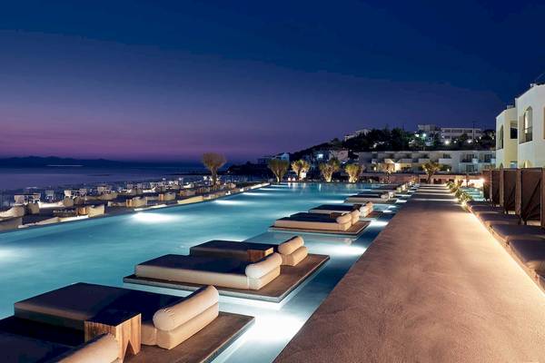 Außenpool des Caravel Hotels bei Nacht mit illuminierten Loungesofas und Blick auf das Meer