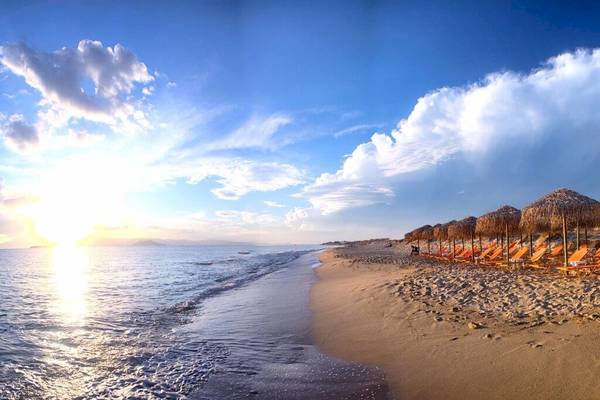 Sonnenuntergang am Strand mit Liegen und Sonnenschirmen auf dem Plaza Beach Hotel.