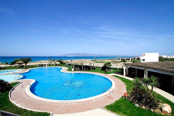 Außenbereich des Plaza Beach Hotels mit Swimmingpool und Blick auf das Meer.