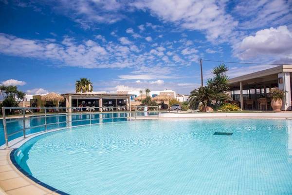 Poolbereich des Plaza Beach Hotels mit blauem Wasser und Sonnenschirmen.