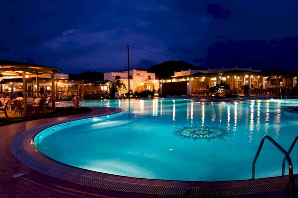 Nachtaufnahme des Plaza Beach Hotels mit beleuchtetem Swimmingpool.