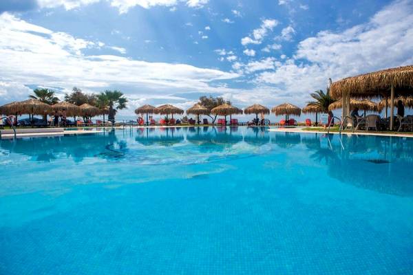 Der Außenpool des Plaza Beach Hotels mit Sonnenschirmen und Liegestühlen.
