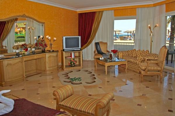 Wohnzimmer im Sea Star Beau Rivage Hotel mit Fernseher, Sofa und Blick auf den Strand
