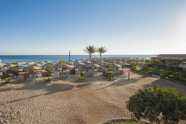 Strandansicht des Sea Star Beau Rivage Hotels mit Sonnenschirmen und Liegen am Meer