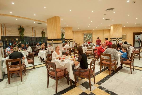 Frühstücksraum im Sea Star Beau Rivage Hotel mit mehreren Gästen, die an Tischen sitzen.