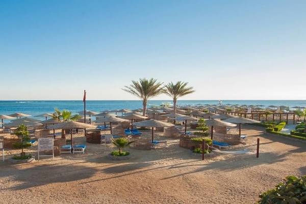 Strandlandschaft des Sea Star Beau Rivage Hotels mit vielen Sonnenschirmen und Liegen.