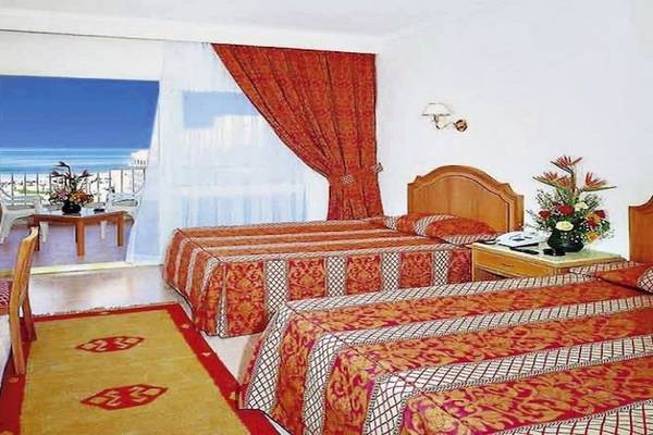 Doppelzimmer im Sea Star Beau Rivage Hotel mit zwei Betten, Fernseher und Balkonzugang.