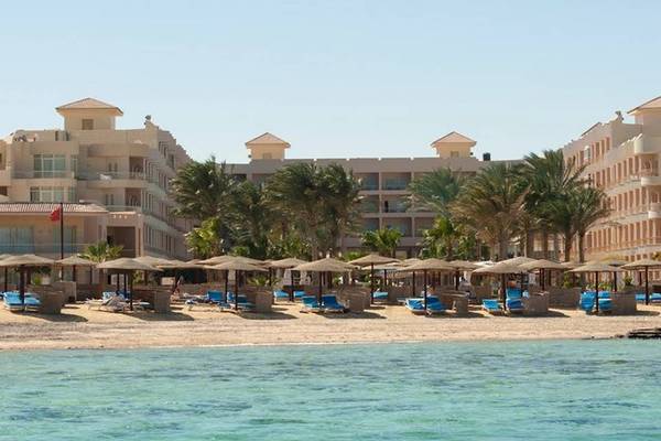 Außenansicht des Sea Star Beau Rivage Hotels mit Strand, Sonnenliegen und Palmen