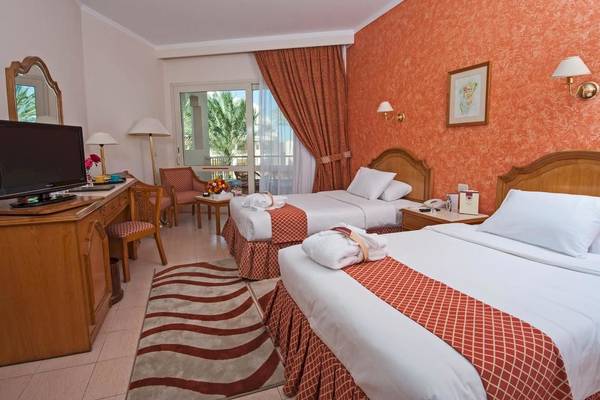 Doppelzimmer im Sea Star Beau Rivage Hotel mit zwei Betten, Fernseher und Fenstern.