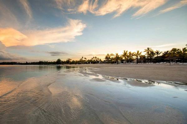 Sonnenuntergang am Long Beach Mauritius mit ruhigem Wasser und Palmen