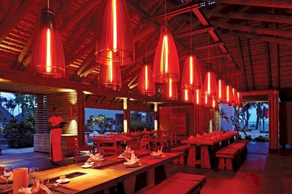 Innenbereich des Long Beach Mauritius Restaurants mit roten Leuchten und gedeckten Tischen.