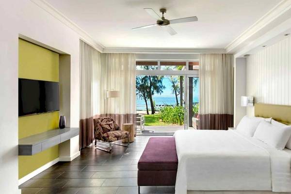 Luxuriöses Hotelzimmer im Long Beach Mauritius mit Blick auf das Meer und eine Terrasse.