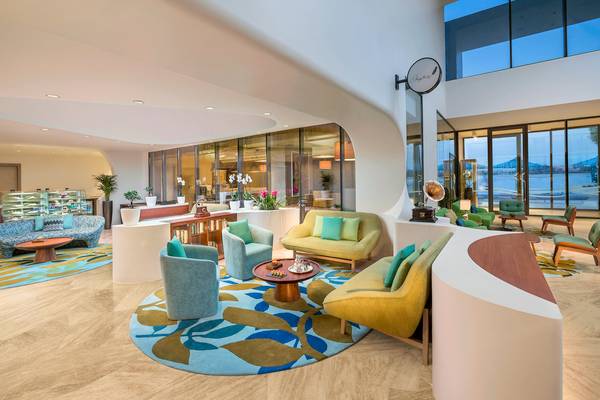 Lobby des The Retreat Palm Dubai MGallery mit modernen Möbeln und blauem Teppich.