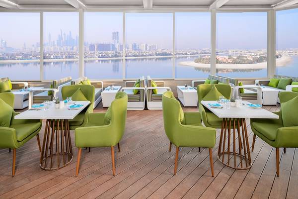Innenansicht des Restaurants The Retreat Palm Dubai MGallery by Sofitel mit Blick auf die Stadt und das Wasser