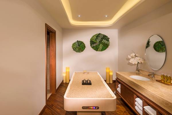 Behandlungsraum im Retreat Palm Dubai MGallery by Sofitel mit Massageliege und Aromalampen.