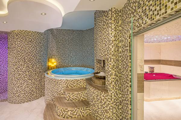 Jacuzzi-Raum im The Retreat Palm Dubai MGallery by Sofitel mit gefliesten Wänden und marmorner Treppe.
