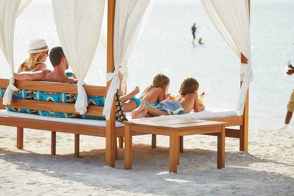 Familie genießt unter einem Baldachin am Strand des W Abu Dhabi - Yas Island