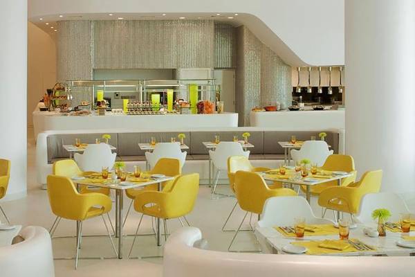 Restaurant im W Abu Dhabi Hotel auf Yas Island mit gelben und weißen Stühlen und Tischen.