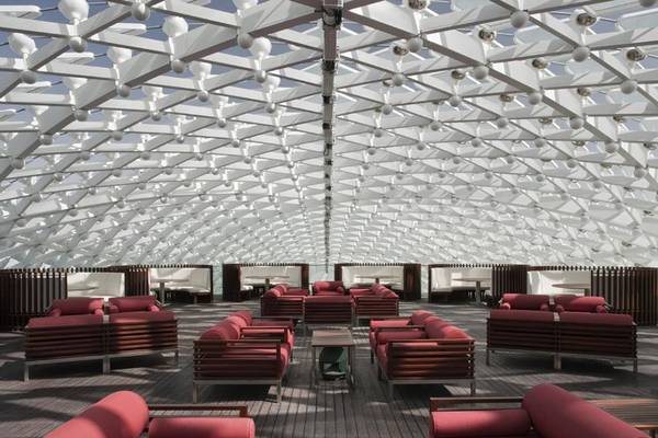 Loungebereich des W Abu Dhabi Hotels auf Yas Island mit roten Sesseln und weißer Dachstruktur.