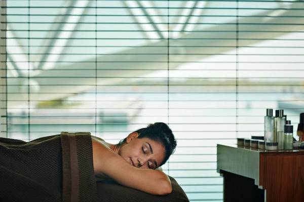 Eine Frau im Hotel W Abu Dhabi entspannt sich auf einer Massageliege.