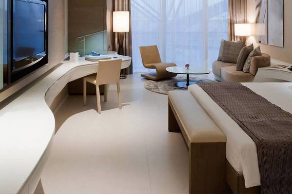 Innenansicht einer Hotelsuite im W Abu Dhabi - Yas Island mit Bett, Schreibtisch, Sesseln und Fernseher.