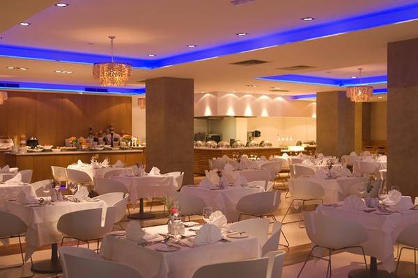 Restaurant des Napa Mermaid Hotel & Suites mit blauen Beleuchtung und weißen Tischen.