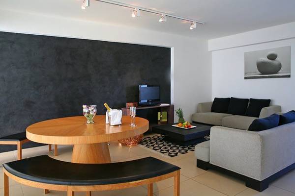 Wohnzimmer im Napa Mermaid Hotel & Suites mit grauem Sofa, Couchtisch und Tisch