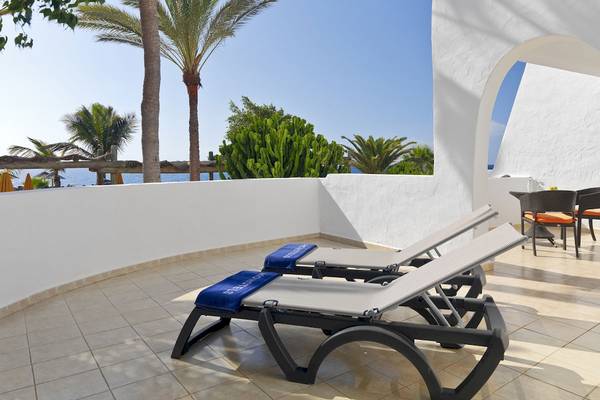 Balkon des H10 Timanfaya Palace mit Liegen und Tisch an einem sonnigen Tag.