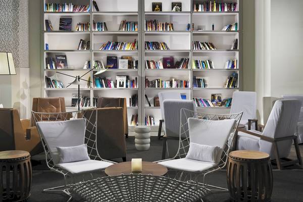 Loungebereich im H10 Timanfaya Palace Hotel mit Bücherregalen, Sesseln und Tischen.
