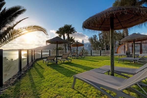 Terrasse des H10 Timanfaya Palace mit Liegen und Sonnenschirmen am Meer