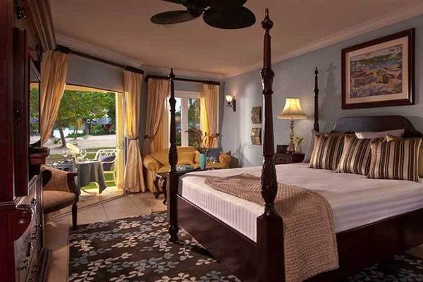 Schlafzimmer im Sandals Whitehouse European Village & Spa mit vierpfostenbett, Lampen und Dekor.