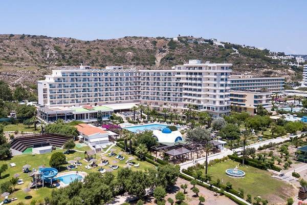 Luftaufnahme des Pegasos Deluxe Beach Hotel Resorts mit mehreren Swimmingpools, Grünflächen und einer Bergkulisse.