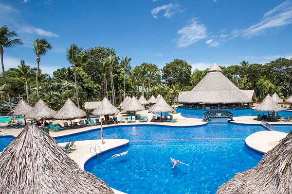 Außenpool des Barcelo Tambor Hotels mit vielen Sonnenschirmen und Liegen.