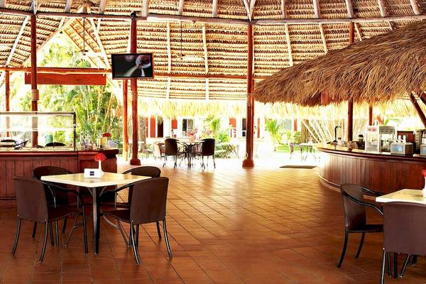 Die Lounge des Barcelo Tambor Hotels mit Tischen, Stühlen und einer Bar.
