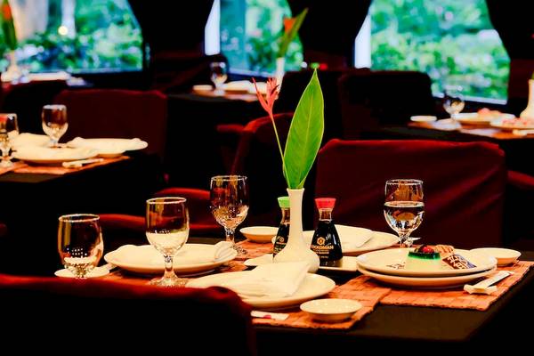 Restauranttisch im Barcelo Tambor Hotel mit Geschirr, Gläsern und Pflanzendekor.