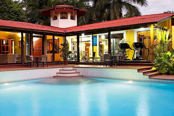 Außenbereich des Barcelo Tambor Hotels mit Swimmingpool, Fitnessgeräten und Sitzgelegenheiten.