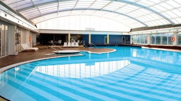 Innenpool im Hotel The Ibiza Twins mit Glasdach und Loungebereich.