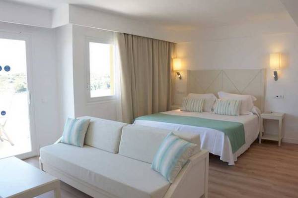 Schlafzimmer im Blau Punta Reina Hotel mit Doppelbett und Schlafsofa.