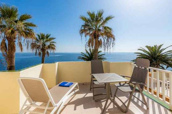 Hotelterrasse mit Blick auf den Ozean und Palmen