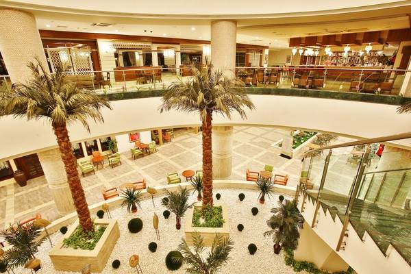 Innenansicht des Sunis Kumköy Beach Resort & Spa mit Palmen und Sitzbereichen.