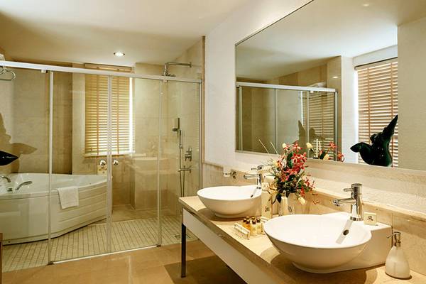 Ein Badezimmer mit zwei Waschbecken, einer Badewanne und einem Spiegel.
