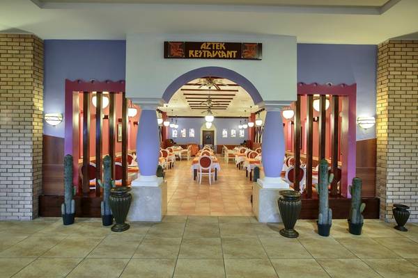 Der Eingangsbereich des Aztec-Restaurants mit einer bogenförmigen Tür und Kaktus-Dekorationen.